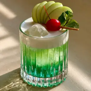 Close up photo of apple island splash with condensation and green apple garnish fan.