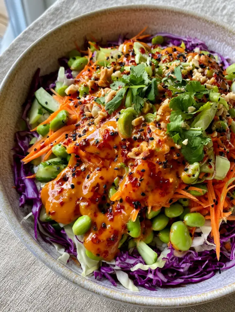 Close up of the flecked red chili oil on a fresh Spicy Asian Salad.
