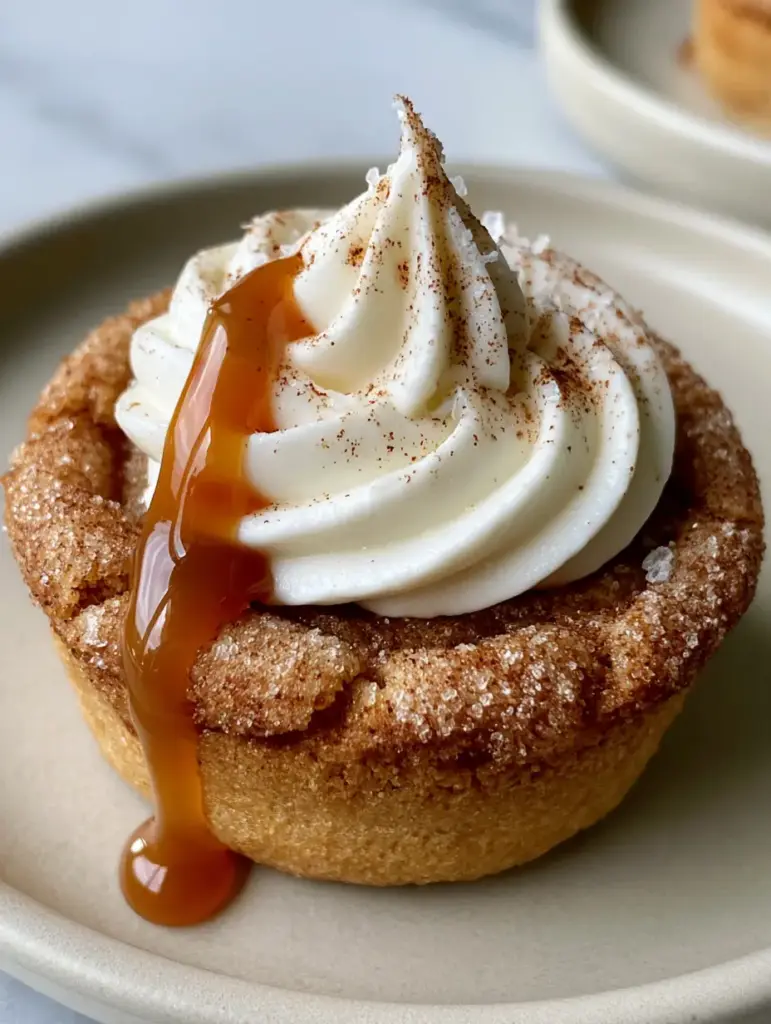 Detailed view of translucent amber caramel drizzling down a cream cheese swirl on a snickerdoodle cookie cup.