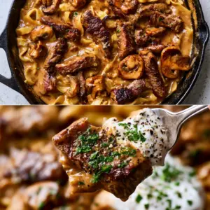 Rustic black cast iron skillet filled with Creamy Meat Dish featuring wavy egg noodles and seared ribeye. (Creamy Meat Dish)