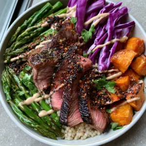 Top-down macro shot of seared steak slices with garlic-herb glaze and quinoa. (healthy dinners for weight loss)